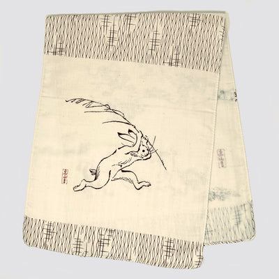 Folded Choju Giga tenugui showing a rabbit running.