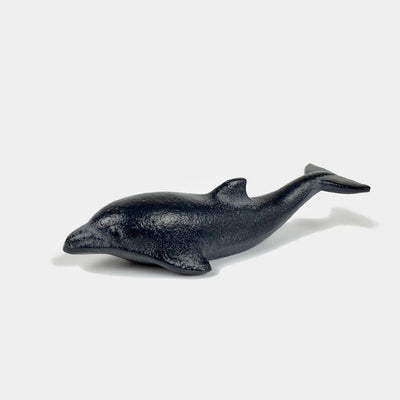 Close-up of a cast iron dolphin paperweight.