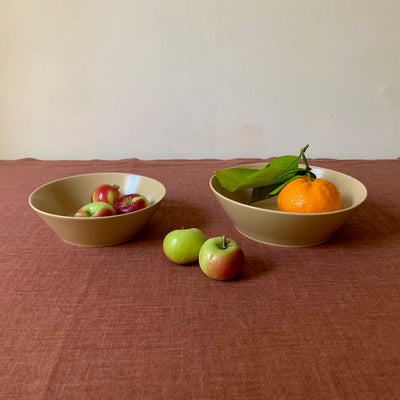 2 sizes of TOH recycled ceramic salad bowl in latte with fruits: 6" with 3 small apples (left), 7" with an orange, and 2 apples sitting between two bowls.