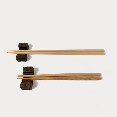 2 sizes of natural Noto sugi chopsticks resting on kiri chopstick rests: regular size (top), child size (bottom).