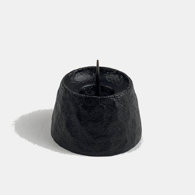 Close-up of a cast iron round candle holder.