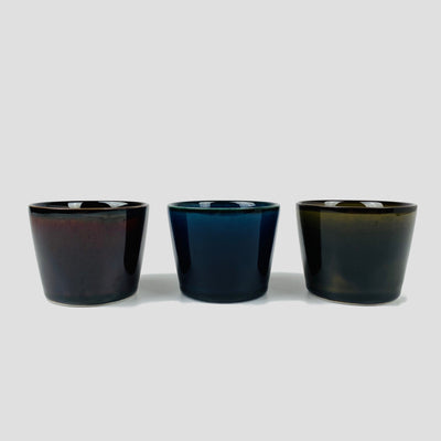 Porcelain cups looked from side: (from left) brown, blue, green.