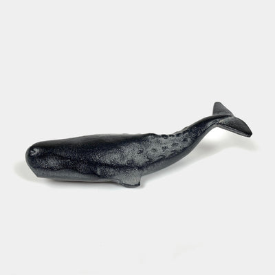 Close-up of a cast iron whale paperweight.