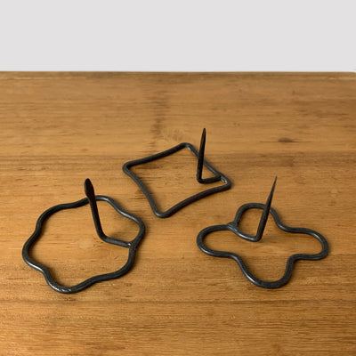 3 styles of wrought iron mosquito coil holders: (from left): flower, square, cross.