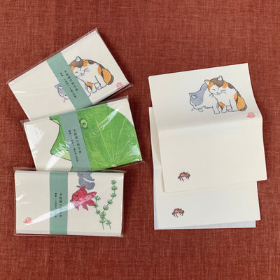 On the left: 3 kinds of kaishi in their packages (from top) "Kittens and a Freshwater Crab", "Tree Frog on Lotus Leaf", "Goldfish in a Bowl". On the right are unfolded sheets of "Kittens and a Freshwater Crab".