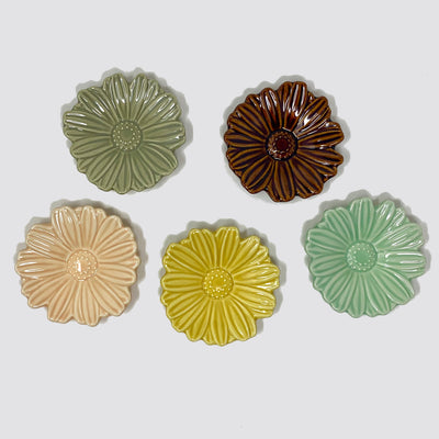 All 5 colors of daisy dish. Clockwise from top left: gray, dark brown, light mint, mustard and light apricot.