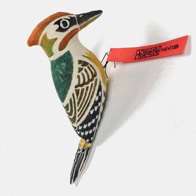 Close up side view of a woodblock print stuffed Japanese green woodpecker.